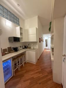 a kitchen with white cabinets and a wooden floor at 7 CENTRALE Rooms & Suite in Milan +5 photos