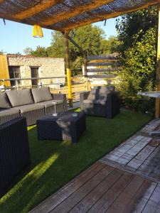 a patio with couches and chairs under a pergola at La loge de la corderie in Marans +2 photos