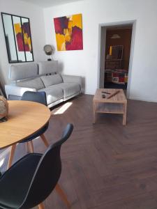 a living room with a couch and a table at La loge de la corderie in Marans