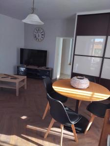 a living room with a table and chairs and a tv at La loge de la corderie in Marans