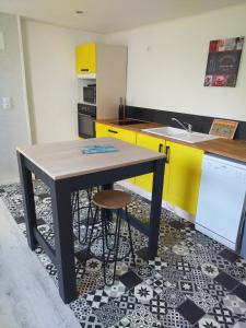 a kitchen with a table and a sink at La loge de la corderie in Marans