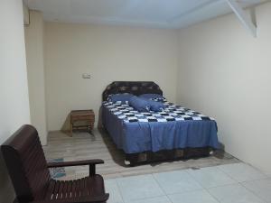 a bedroom with a bed and a chair at Homestay Zanoleos in Tomohon