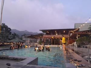 a group of people sitting in a swimming pool at Homestay Zanoleos in Tomohon
