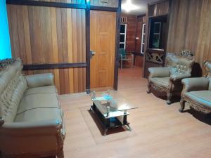 a living room with two couches and a glass table at Homestay Zanoleos in Tomohon