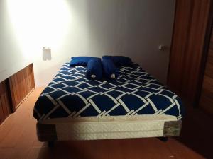 a bed with a blue stuffed animal laying on it at Homestay Zanoleos in Tomohon