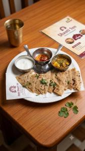 a plate of food on a table with some food at Hotel Shannti Inn with Ganges View in Varanasi