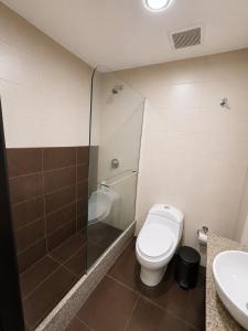 a bathroom with a toilet and a glass shower at Gran Propiedad en Guayaquil in Guayaquil