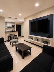 a living room with a large flat screen tv at Gran Propiedad en Guayaquil in Guayaquil