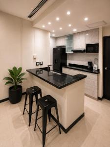 a kitchen with a counter and two stools in it at Gran Propiedad en Guayaquil in Guayaquil