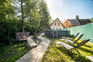 a group of chairs in a yard with a house at Ubytování Pod Mostem in Broumov