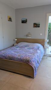 a bedroom with a bed with a purple comforter at Campagne Carbonel in Aix-en-Provence