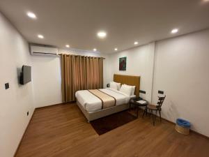 a bedroom with a bed and a table and a chair at Hotel Heranya in Kathmandu