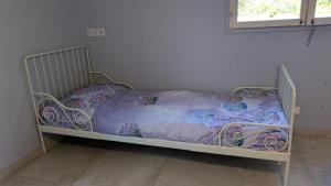 a bed with a purple comforter in a room at Campagne Carbonel in Aix-en-Provence