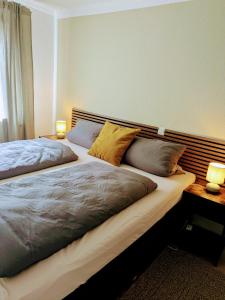 a bedroom with a large bed with two pillows at Gasthof Schausten in Kreuztal +9 photos