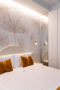 a bedroom with a white bed with orange pillows at DELL'EDERA Luxury Home in Polignano a Mare