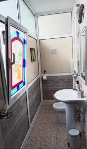 a bathroom with a sink and a toilet and a window at Casa Emma in Cremolino