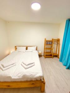 a bedroom with a large bed with white sheets at Cozy Dez Guest House with Dreamy Mountain Views in Margahovit