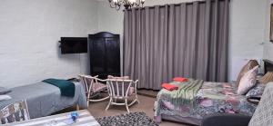 a living room with a bed and a couch at Peacock Cove Self Catering Studio in Gordonʼs Bay