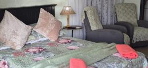 a bedroom with a bed with pillows and a table at Peacock Cove Self Catering Studio in Gordonʼs Bay