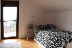 a bedroom with a black and white bed and a window at Sunset Home in Vršac