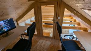 an attic office with a desk with a computer and chairs at Sunset Home in Vršac