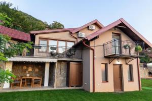 a house with a balcony and a table at Sunset Home in Vršac