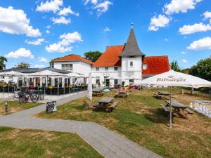 a building with tables and umbrellas in front of it at Hotel Bloemfontein in Borkum