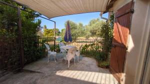 a patio with a table and chairs and an umbrella at Campagne Carbonel in Aix-en-Provence