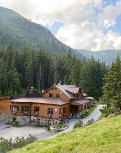 a large wooden house in the middle of a mountain at bouda Pod Sněžkou in Pec pod Sněžkou