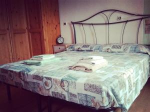 a bedroom with a bed with a quilt on it at Casa Emma in Cremolino