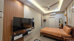a hospital room with a bed and a large tv at Peacock Studio Tiny House in Kuala Terengganu