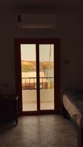 a room with a door to a balcony with a view at sunset guest house in Aswan +94 photos
