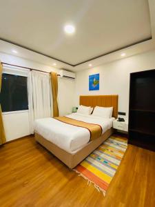 a bedroom with a large bed and a flat screen tv at Hotel Heranya in Kathmandu