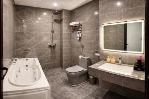 a bathroom with a tub and a toilet and a sink at PARIS DELI HOTEL - Vạn Phúc in Hà Ðông +16 photos