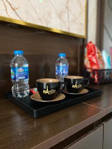 two cups of coffee and two bottles of water on a tray at PARIS DELI HOTEL - Vạn Phúc in Hà Ðông