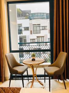 a room with a table and two chairs and a large window at PARIS DELI HOTEL - Vạn Phúc in Hà Ðông