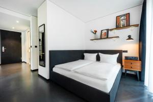 ein Schlafzimmer mit einem großen weißen Bett in einem Zimmer in der Unterkunft Brera Serviced Apartments Munich Schwabing in München + 39 Fotos