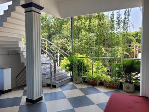 a balcony with stairs and potted plants at Nivaa Stays - Near JIPMER in Pondicherry