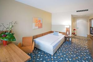 ein Hotelzimmer mit einem Bett und einem Stuhl in der Unterkunft Best Western Hotel President in Bonn + 111 Fotos