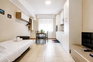 Grab a Flat in Coroneo في ترييستي: غرفة نوم بها سرير ومطبخ به طاولة