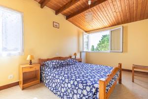a bedroom with a bed with a blue comforter and two windows at Duplex N°2 - Résidence Balnéaire in Le Port-des-Barques