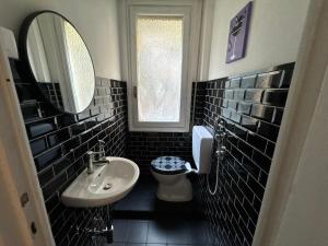 a bathroom with a sink and a toilet and a mirror at KALEIDO Hostel in Genoa +32 photos