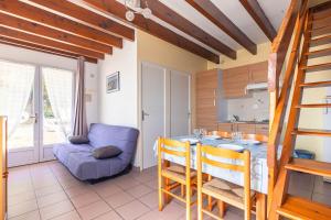 a kitchen and dining room with a table and a couch at Duplex N°2 - Résidence Balnéaire in Le Port-des-Barques