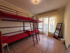 a room with two bunk beds and a ladder at KALEIDO Hostel in Genoa