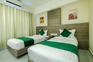 two beds in a hotel room with at The Heartland Business Hotel in Trivandrum
