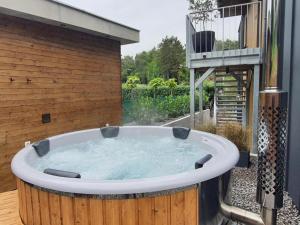 a hot tub in a backyard with a balcony at R&J apartmány in Bojnice