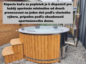a large wooden tub sitting outside of a building at R&J apartmány in Bojnice