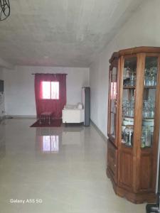 a living room with a wooden cabinet and a couch at Villa TSARAJORO in Toamasina