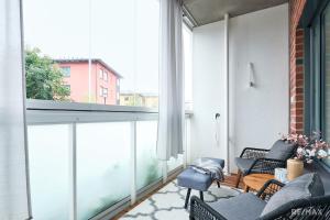 an apartment with a balcony with chairs and a large window at Modern two-bedroom apartment in Espoo