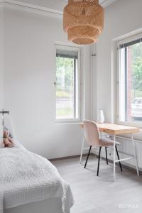 a bedroom with a bed and a desk and a table at Modern two-bedroom apartment in Espoo